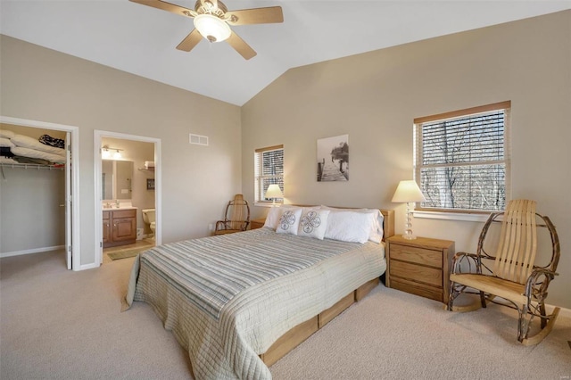 bedroom with a closet, light colored carpet, visible vents, a spacious closet, and vaulted ceiling