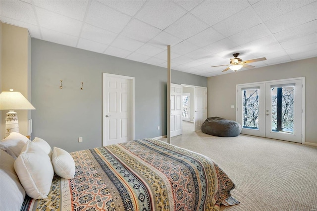 bedroom featuring a paneled ceiling, a ceiling fan, access to exterior, french doors, and carpet floors