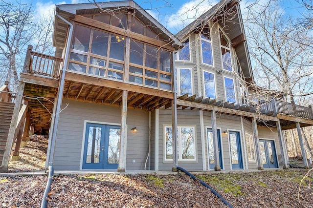 back of property featuring a sunroom, stairway, and french doors