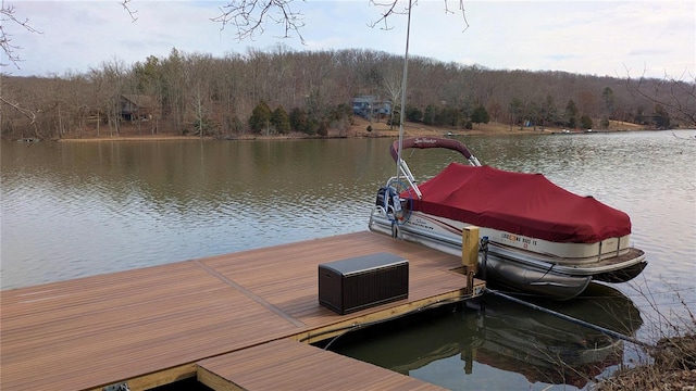 view of dock with a water view and a forest view