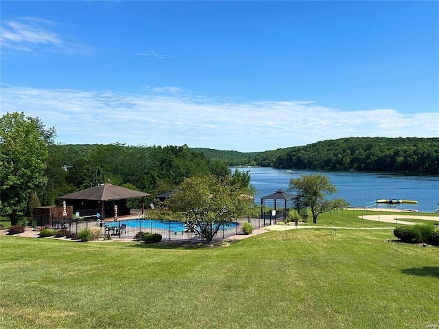 exterior space featuring a water view, a lawn, a view of trees, and a gazebo