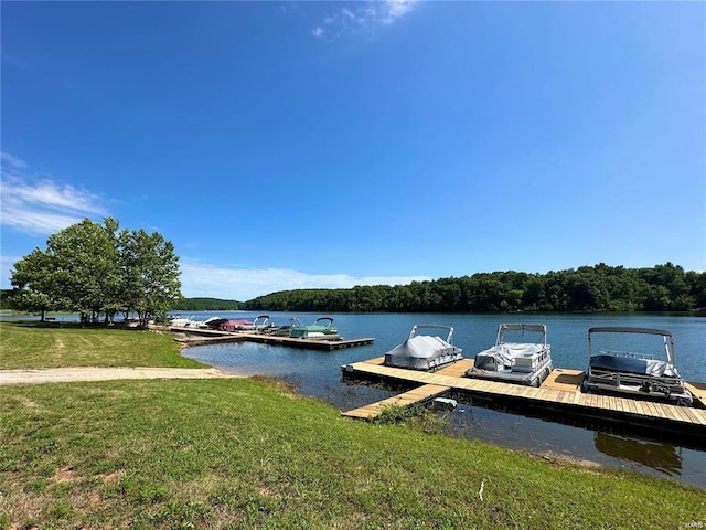 view of dock with a yard and a water view