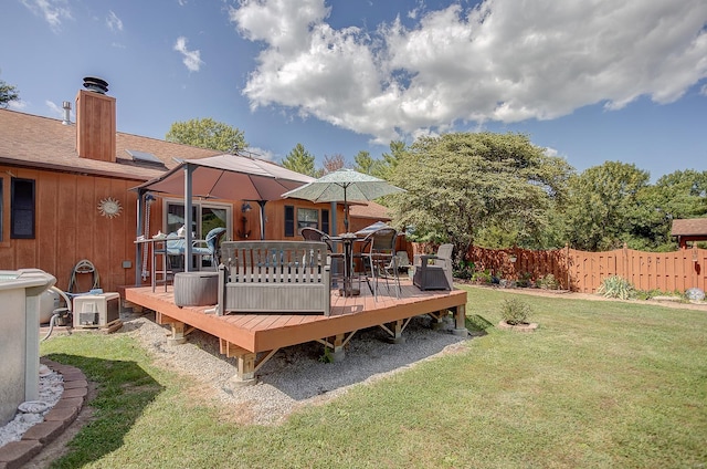 rear view of house featuring a wooden deck and a yard