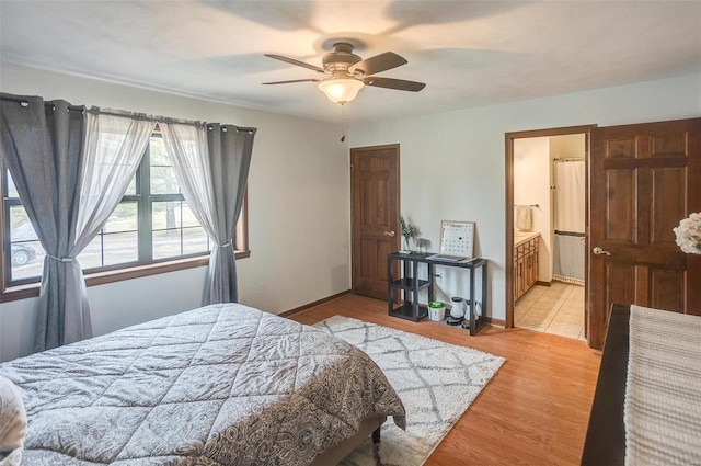 bedroom featuring ceiling fan, ensuite bathroom, and light hardwood / wood-style floors