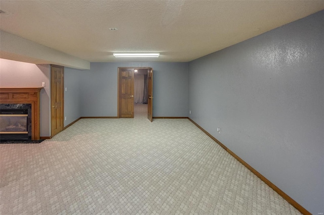 basement with a premium fireplace, light carpet, and a textured ceiling