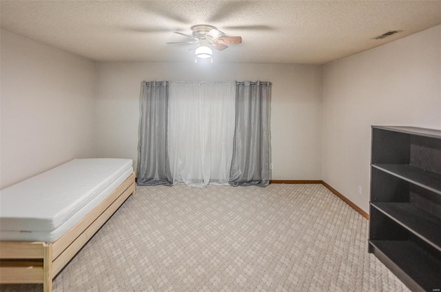 bedroom with ceiling fan and a textured ceiling