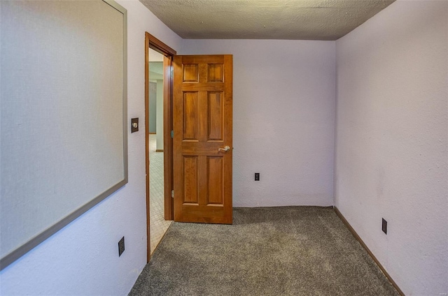 carpeted empty room with a textured ceiling