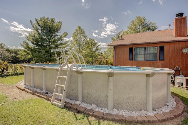 view of swimming pool with a yard