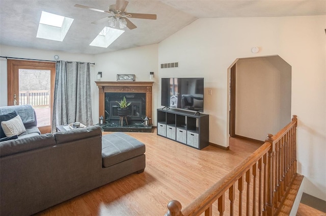 living room with hardwood / wood-style flooring, ceiling fan, and lofted ceiling