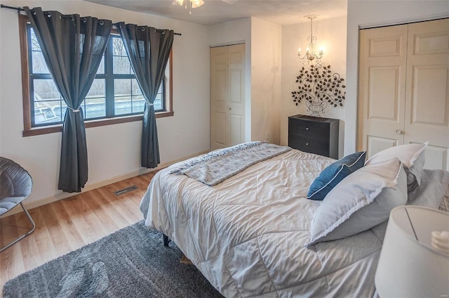 bedroom with an inviting chandelier, hardwood / wood-style flooring, and a closet