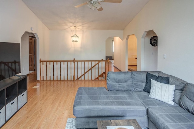 living room with lofted ceiling, ceiling fan, and light hardwood / wood-style flooring