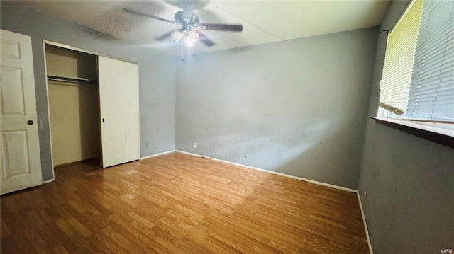 unfurnished bedroom with a closet, ceiling fan, and wood-type flooring