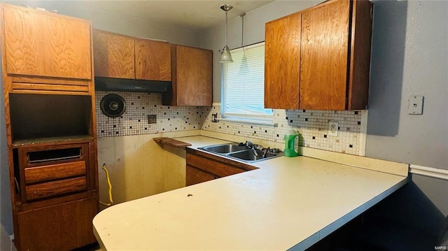 kitchen featuring sink, pendant lighting, and backsplash