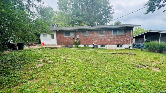 back of house with a patio and a lawn