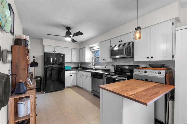 kitchen featuring sink, white cabinetry, decorative light fixtures, kitchen peninsula, and stainless steel appliances