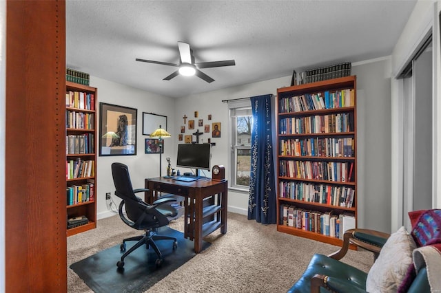 carpeted home office with ceiling fan and a textured ceiling