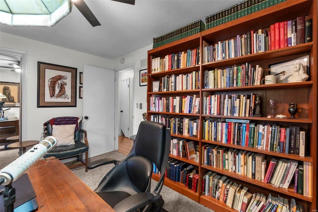 carpeted home office featuring ceiling fan