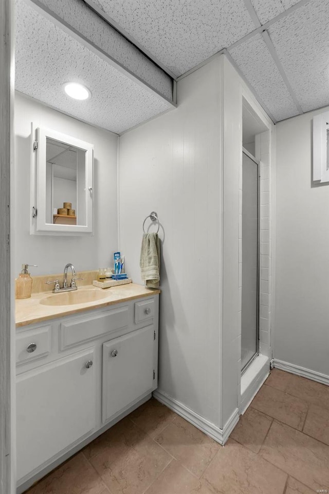 bathroom featuring vanity, a paneled ceiling, and walk in shower