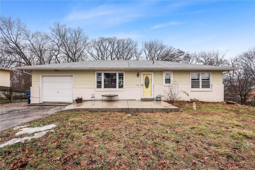 single story home with a garage, a patio, and a front yard