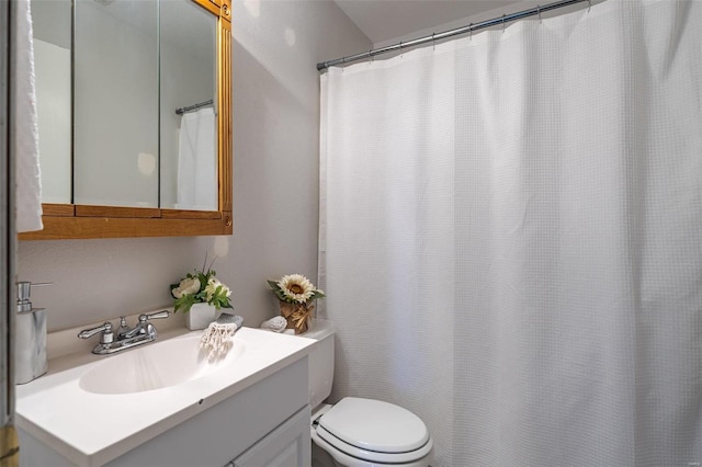 bathroom featuring walk in shower, vanity, and toilet