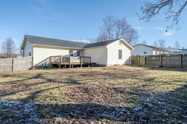 back of house with a lawn and a deck