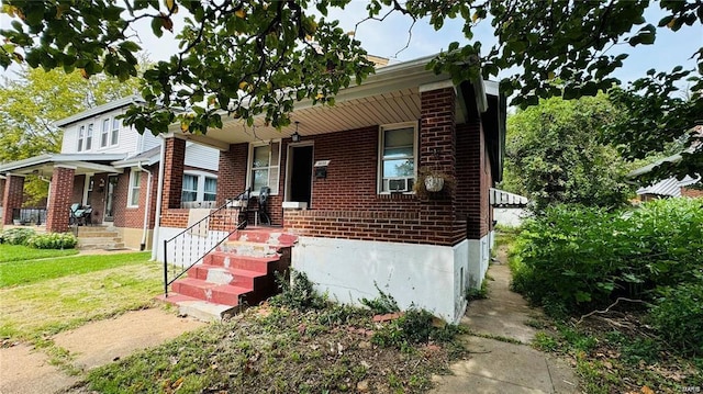 view of front of house with cooling unit, covered porch, and a front yard