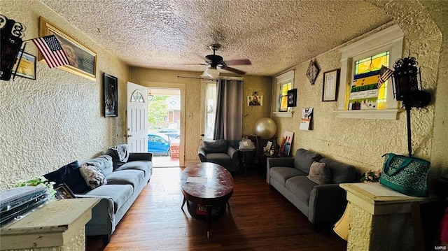 living room with ceiling fan, hardwood / wood-style flooring, and a textured ceiling