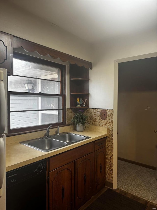 kitchen with dark brown cabinetry, sink, fridge, and black dishwasher