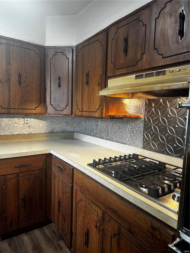 kitchen featuring stainless steel gas stovetop, tasteful backsplash, dark brown cabinets, and dark hardwood / wood-style floors