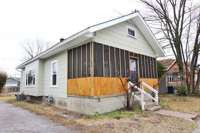 view of front of home with a sunroom and cooling unit