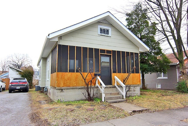 view of front of home featuring a sunroom and central AC unit