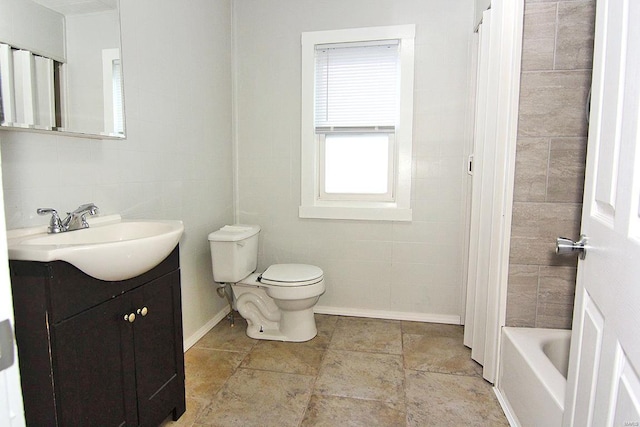 bathroom featuring vanity, tile walls, and toilet