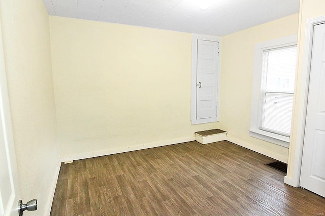 spare room featuring dark wood-type flooring