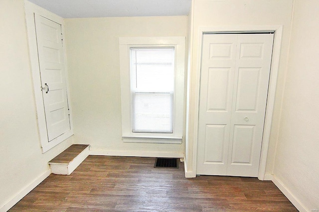 unfurnished bedroom featuring dark wood-type flooring and a closet