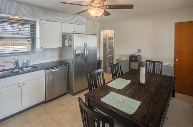 kitchen with sink, appliances with stainless steel finishes, ceiling fan, decorative backsplash, and white cabinets