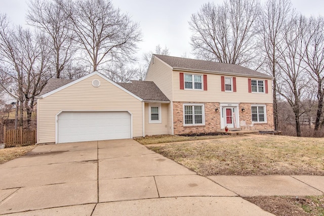 colonial home featuring a garage and a front lawn