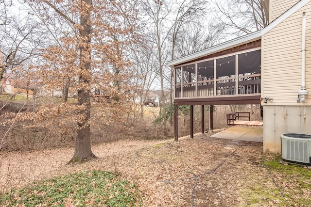 view of yard with a patio area, a sunroom, and central air condition unit