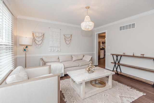 living room with ornamental molding, a notable chandelier, and dark hardwood / wood-style flooring