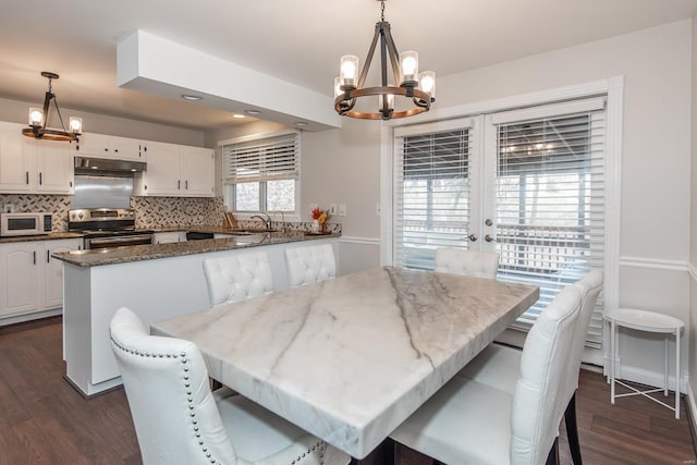 dining area featuring french doors, dark hardwood / wood-style floors, a chandelier, and sink