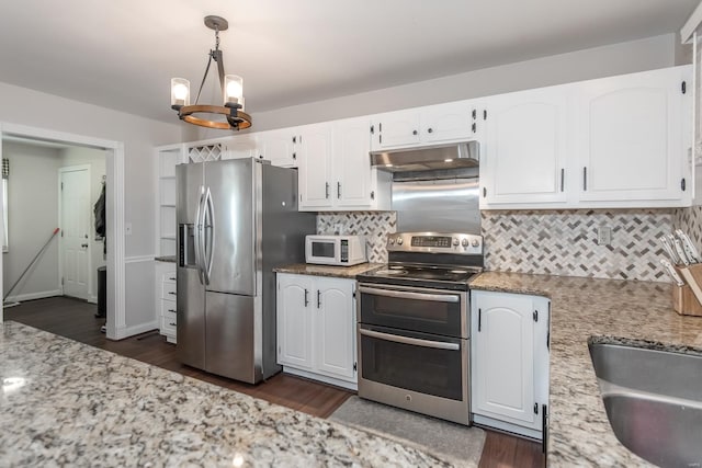 kitchen featuring pendant lighting, appliances with stainless steel finishes, white cabinetry, light stone counters, and tasteful backsplash