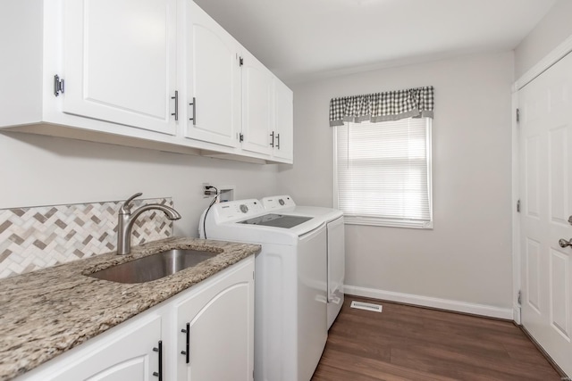 laundry room with cabinets, washing machine and dryer, sink, and dark hardwood / wood-style flooring