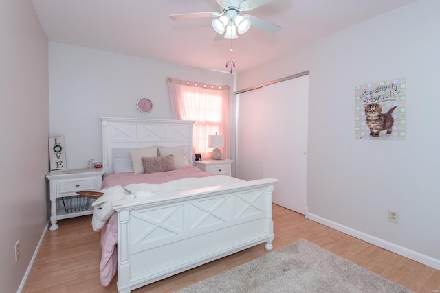 bedroom with ceiling fan, light hardwood / wood-style floors, and a closet