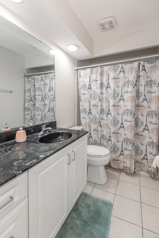 bathroom featuring vanity, tile patterned flooring, and toilet