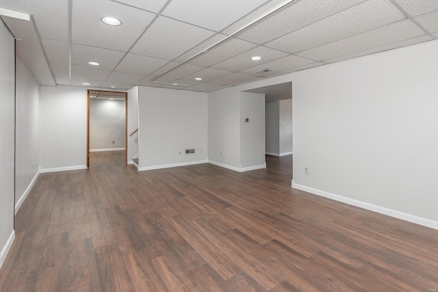 spare room with dark hardwood / wood-style floors and a drop ceiling