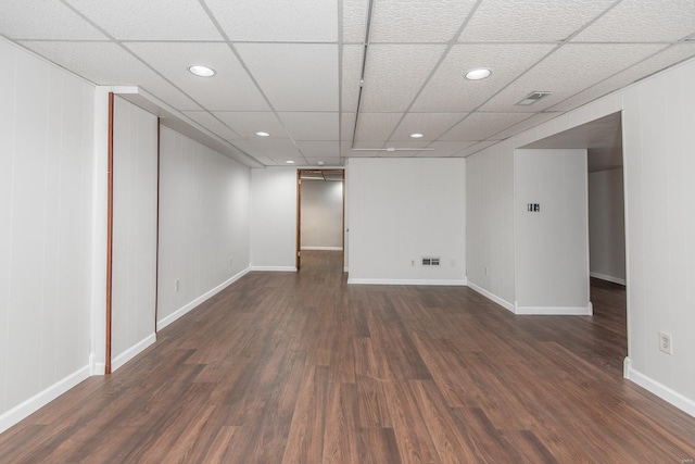 empty room with dark wood-type flooring and a paneled ceiling