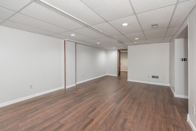 basement with a drop ceiling and dark hardwood / wood-style floors