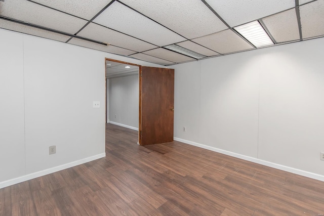 empty room featuring a drop ceiling and hardwood / wood-style floors