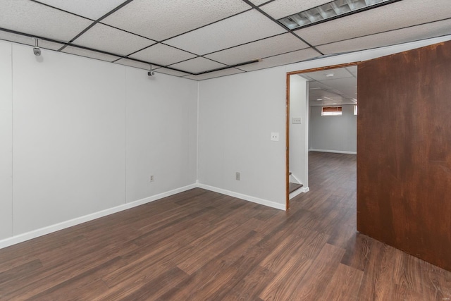 empty room featuring a drop ceiling and dark hardwood / wood-style floors