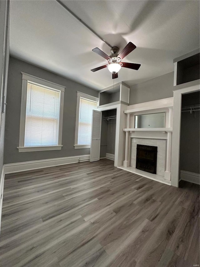 unfurnished living room with ceiling fan, a fireplace, and hardwood / wood-style floors