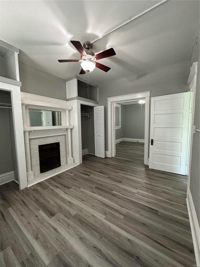 unfurnished living room with ceiling fan and dark hardwood / wood-style flooring